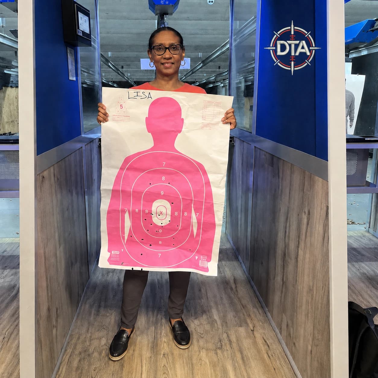 Student Lisa holds her target after first pistol training session — Down-Range Training Academy
